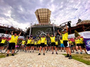 policyjni cykliści trzymają w rekach rowery podniesione do góry