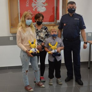 Wspólne zdjęcie Komendanta Powiatowego Policji inspektora Krzysztofa Kozyry z rodziną chłopca, który otrzymał upominek i dyp