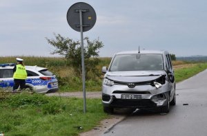 uszkodzony samochód na poboczu drogi, w tle policjantka stoi przy radiowozie