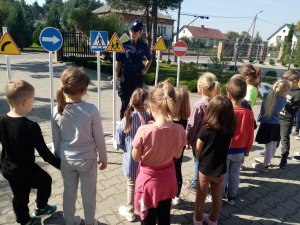 policjantka prezentuje dzieciom znaki drogowe