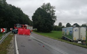 Czerwony parawan na miejscu wypadku. Uszkodzone pojazdy