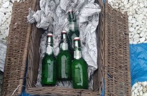 butelki po piwie leżące w koszu wiklinowym