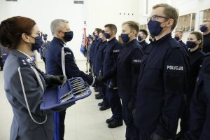 Komendant Wojewódzki Policji w Lublinie wręcza legitymację nowym funkcjonariuszom.