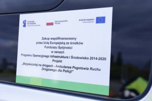 Zdjęcie naklejki na szybie radiowozu z napisem : Zakup współfinansowany przez Unię Europejską ze środków Funduszu Spójności w ramach Programu Operacyjnego Infrastruktura i Środowisko 2014-2020.