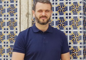 zdjęcie przedstawia mężczyznę w niebieskiej koszulce na kolorowym tle (1)Dariusz Szydełko