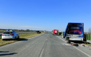 samochód dostawczy z rozbitym tyłem, po lewej radiowóz z przodu osobowy i straż pożarna na drodze