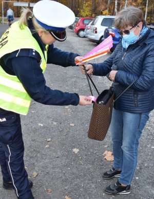 policjant rozdaje odblask kobiecie