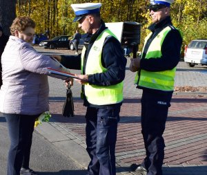 policjant rozdaje odblask kobiecie