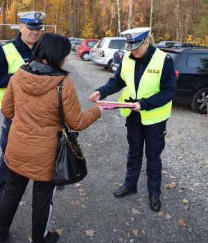 policjant rozdaje odblask kobiecie