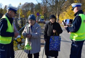 policjanci rozdają starszym kobietom odblaski