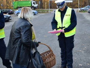 policjantka rozdaje kobiecie odblask