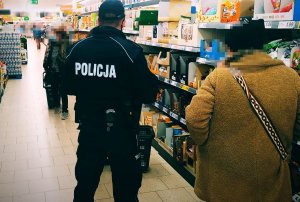 policjant w trakcie kontroli w placówce handlowej