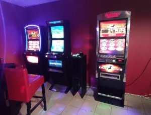 Trzy automaty do gier stojące w lokalu
