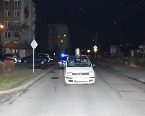 samochód marki Fiat stojący na środku ulicy. Za min widać fragment radiowozu