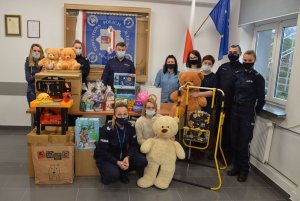 zdjęcie grupowe policjantów i pracowników cywillnych z zebranymi rzeczami