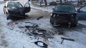 Dwa rozbite samochody stojące na jezdni.