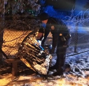 Policjant okrywa kocem termicznym mężczyznę