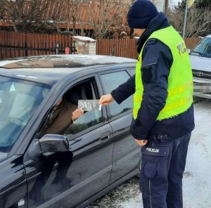 policjant wreczajacy ulotke kampanii z napisem czy to cię tłumaczy