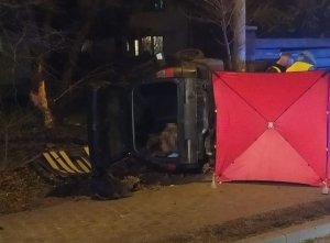 Rozbity seat na miejscu wypadku, czerwony parawan i policjanci