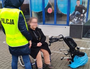 policjantka stoi przy kobiecie na wózku , obok odzyskana przystawka do wózka inwalidzkiego