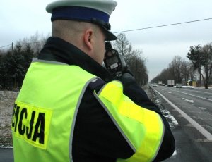 policjant z miernikiem prędkości na drodze