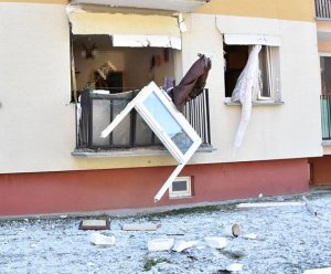 uszkodzone drzwi i ono balkonowe mieszkania. Widoczne sprzęty, które siła eksplozji wyrzuciła na zewnątrz