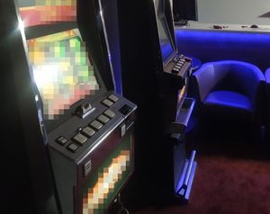 automaty do gier, w tle niebieskie fotele i lada