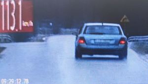 widok z ekranu videorejestratora biały samochód jadący z prędkością 113 kilometrów na godzinę