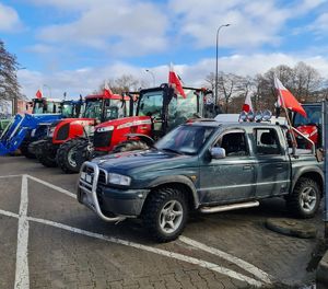 policjant zabezpiecza protest rolników, pojazdy stojące w szeregu