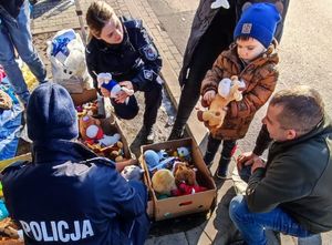 policjanci rozdają pluszaki dla dzieci uchodźców z Ukrainy