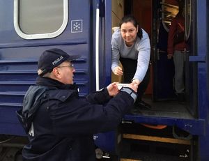 policjant podaje zupę pasażerce pociągu