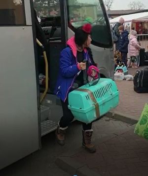 kobieta wysiada z autokaru z transporterem na zwierzęta