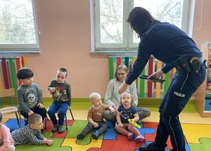 policjantka w przedszkolu rozdaje dzieciom odblaski