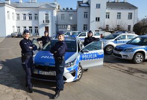 4 policjantki stojace przy oznakowanym radiowozie