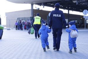 policjantka prowadzi dwójkę małych dzieci