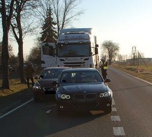 Uszkodzone samochody stoją na jezdni za nimi samochód ciężarowy