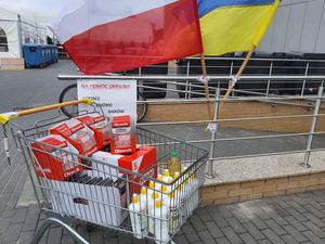 zebrane dary w wózku, obok widać dwie flagi biało czerwona i niebiesko żółta.