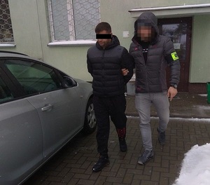 policjant prowadzi zatrzymanego