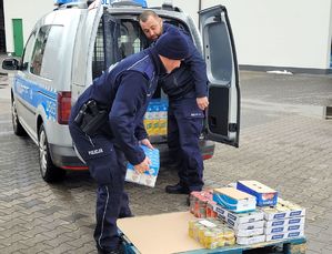 policjanci pakujący artykuły spożywcze do radiowozu 2