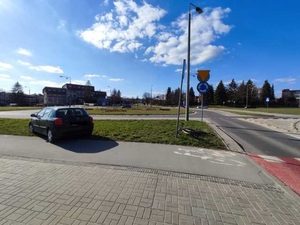 ciemny samochód osobowy i leżący rower