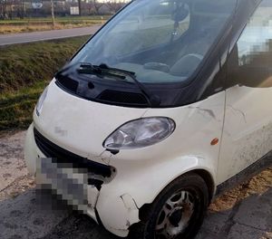 Biały pojazd marki Smart z uszkodzeniami po wypadku