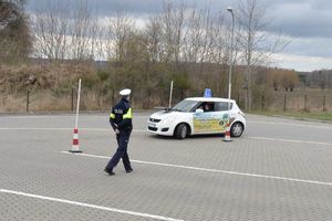 policjant na torze jazdy, obok kobieta ćwiczy w pojeździe
