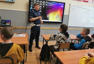 policjant służb ruchu drogowego mówi do młodzieży w sali lekcyjnej