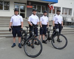 czterech policjantów z patrolu rowerowego stoi przed rowerami