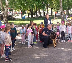 policjant z psem oraz przedszkolaki z opiekunem