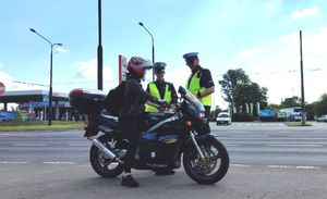 policjanci kontrolują motocyklistkę na drodze