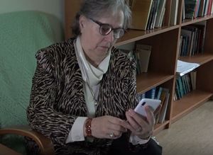 zdjęcie poglądowe. kobieta siedzi na fotelu, w ręku trzyma telefon