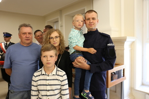 Zdjęcie przedstawia nowego policjanta wraz z rodziną.