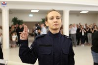 Policjantka z podniesioną dłonią i wyprostowanymi dwoma palcami ślubuje na sztandar Komendy Wojewódzkiej Policji w Lublinie.