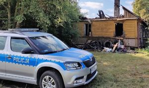 dom spalony w wyniku pożaru, obok radiowóz